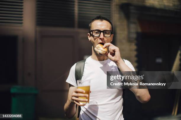 man with sandwich and beer outdoors - eating on the move stock pictures, royalty-free photos & images