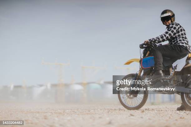 man on the cool bike at the hazy beach - motorcycle stunt stock pictures, royalty-free photos & images