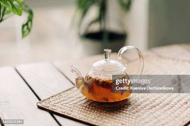 tea with sea buckthorn in glass teapot, selective focus, rustic background, square image - ティーポット ストックフォトと画像