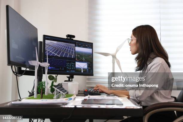 portrait beautiful asian woman work on computer with model of wind turbine and solar panel,solar cell.renewable energy sustainability concept.banner cover design for electricity. - power supply stock pictures, royalty-free photos & images