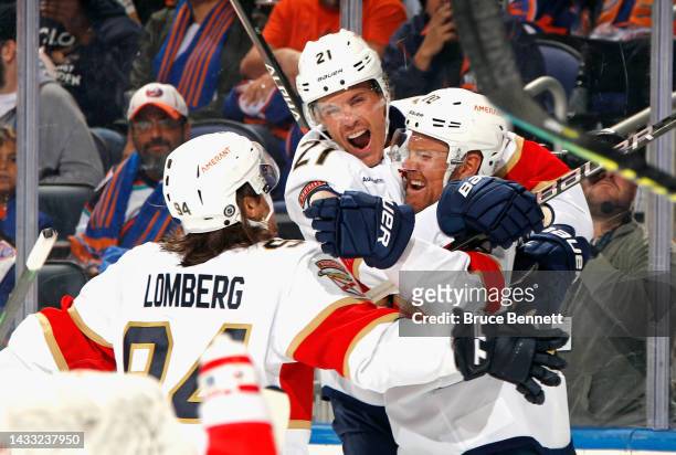 Patric Hornqvist of the Florida Panthers scores a third period goal against the New York Islanders and is joined by Ryan Lomberg and Nick Cousins at...