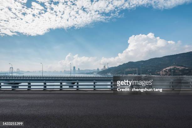 side view of the road surface of cross-sea bridge - parapetto barriera foto e immagini stock