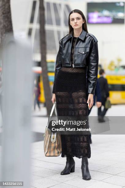 Guest wears a leather jacket, Burberry bag, black boots with a mesh full length outfit outside Dongdaemun Design Plaza at Seoul Fashion Week SS 23 on...