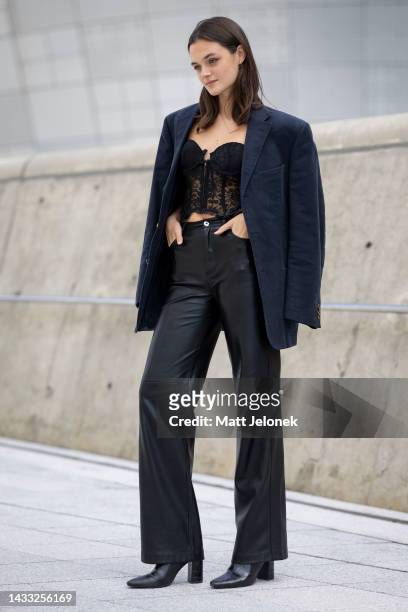 Guest wears a dark blue jacket, lace top with black pants outside Dongdaemun Design Plaza at Seoul Fashion Week SS 23 on October 14, 2022 in Seoul,...