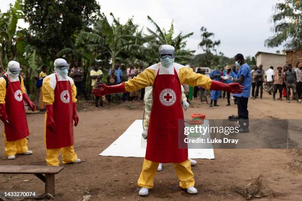 Red Cross workers doff PPE after burying a 3-year-old boy suspected of dying from Ebola on October 13, 2022 in Mubende, Uganda. Emergency response...