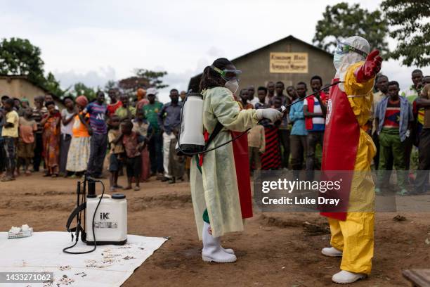 Red Cross workers don PPE prior to burying a 3-year-old boy suspected of dying from Ebola on October 13, 2022 in Mubende, Uganda. Emergency response...