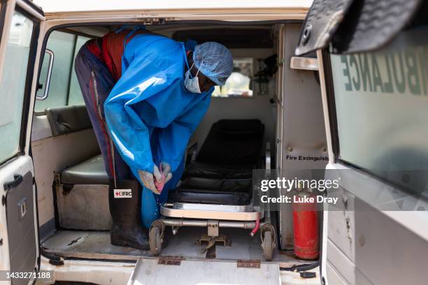 Red Cross workers clean ambulances after transporting Ebola victims to hospital on October 13, 2022 in Mubende, Uganda. Emergency response teams,...