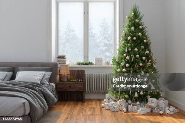 modernes schlafzimmerinterieur mit weihnachtsbaum, geschenkboxen, unordentlichem bett und verschneitem blick aus dem fenster - gift box tag stock-fotos und bilder