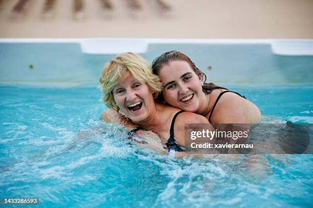 candid vacation portrait of mother and daughter in swim spa - girls in hot tub stockfoto's en -beelden