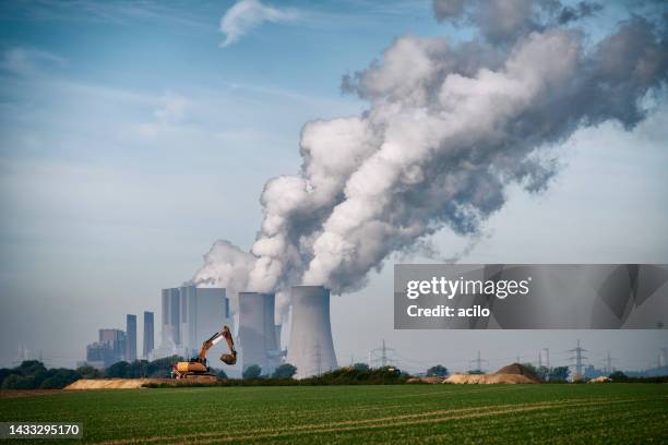 excavator in front of a coal fired power plant - coal fired power station stock pictures, royalty-free photos & images