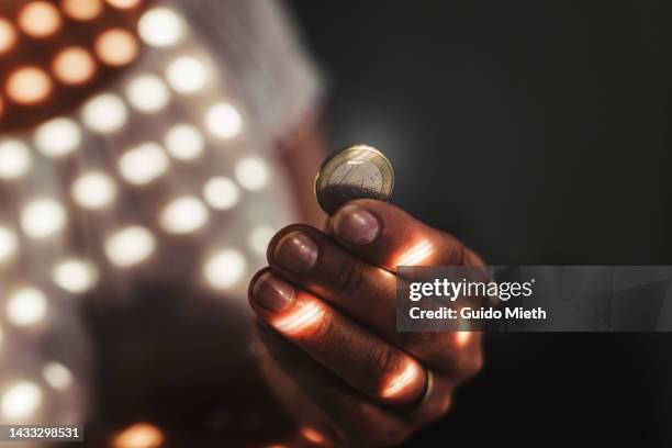 woman holding one euro coin in her hand. - 1 euro stock-fotos und bilder