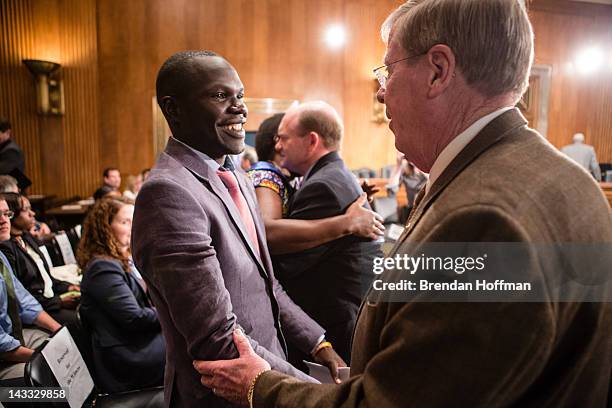 Jacob Acaye, a former LRA abductee whose story was highlighted in the recent KONY 2012 video produced by the charity Invisible Children, shakes hands...