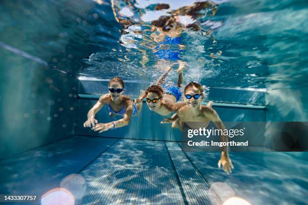 niños adolescentes nadando bajo el agua en la piscina - girl diving fotografías e imágenes de stock