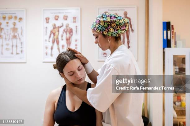 physiotherapist working with female patient in clinic - osteopathie stockfoto's en -beelden