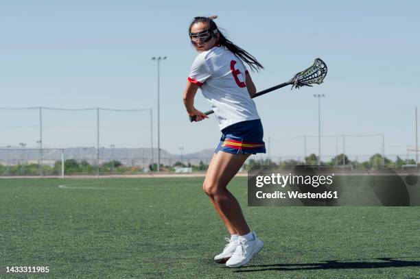 player with lacrosse stick playing on sports field - lacrosse stock pictures, royalty-free photos & images