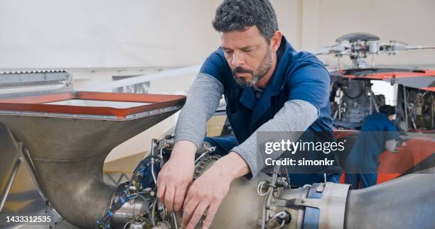 meccanico che ripara il motore dell'elicottero - punto di vista dellelicottero foto e immagini stock