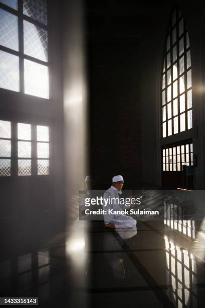 muslim man praying with prayer beads in mosque - imam stock pictures, royalty-free photos & images