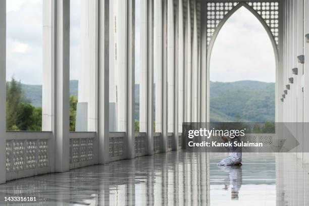 muslim man is praying in mosque - makkah mosque stockfoto's en -beelden