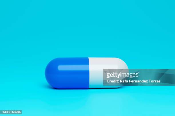 blue and white medicine capsule on blue background - tablet 3d stock pictures, royalty-free photos & images
