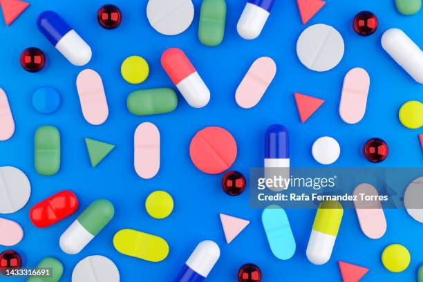creative layout of pills and capsules on blue background - generiskt läkemedel bildbanksfoton och bilder