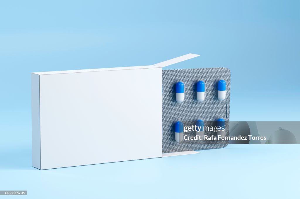 Blank packaging and medical capsules close up