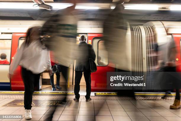 businessman surrounded by commuters at subway station - metro de londres imagens e fotografias de stock