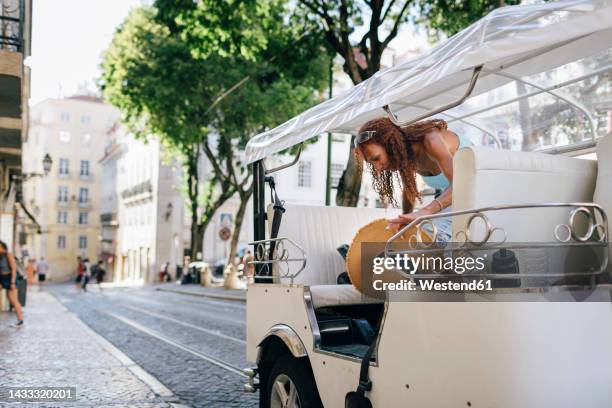 young woman disembarking from tuktuk - auto riquexó imagens e fotografias de stock