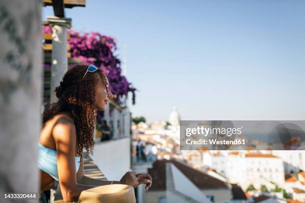 thoughtful young woman with curly hair leaning on wall - lisbon tourist stock pictures, royalty-free photos & images