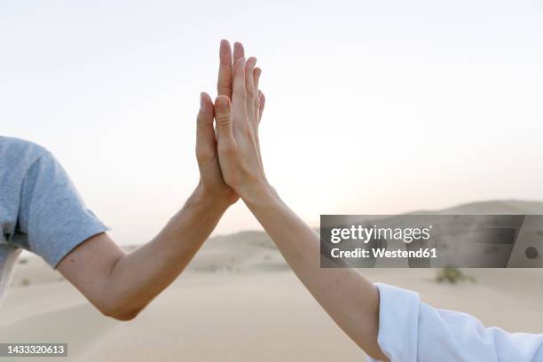 hands of couple giving high-five in desert at sunset - give five sky stock pictures, royalty-free photos & images