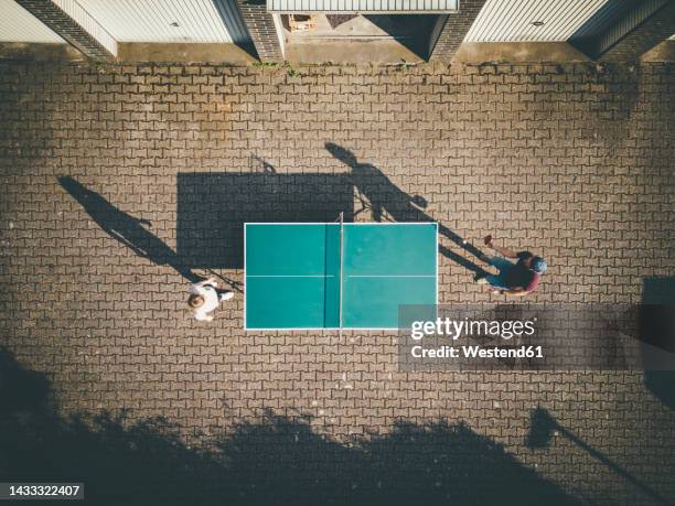 man with daughter playing table tennis at back yard - tennis de table photos et images de collection