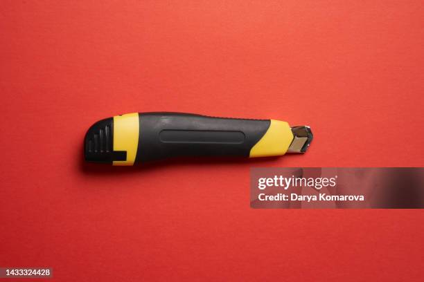 box cutter knife on the isolated red background. office supplies for your design. top view, flat lay with copy space. - plastic design furniture stock pictures, royalty-free photos & images