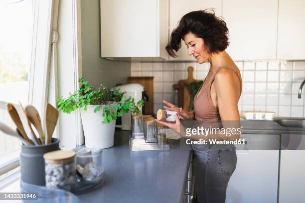 woman labeling jar standing at kitchen counter - jars kitchen stock pictures, royalty-free photos & images