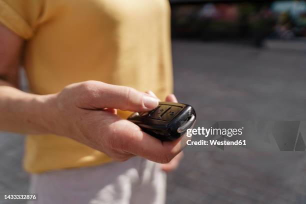 hand of mature woman holding car key - car keys hand foto e immagini stock