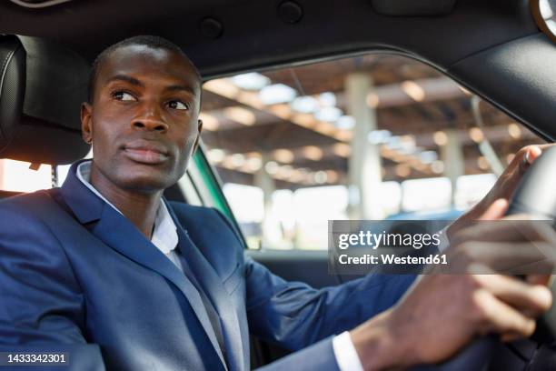 thoughtful young businessman driving car - selective focus imagens e fotografias de stock