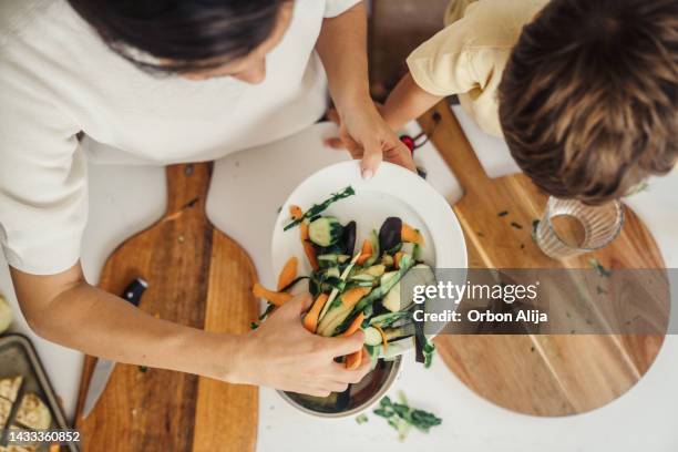 mother and son making compost from vegetable leftovers - leftovers stock pictures, royalty-free photos & images