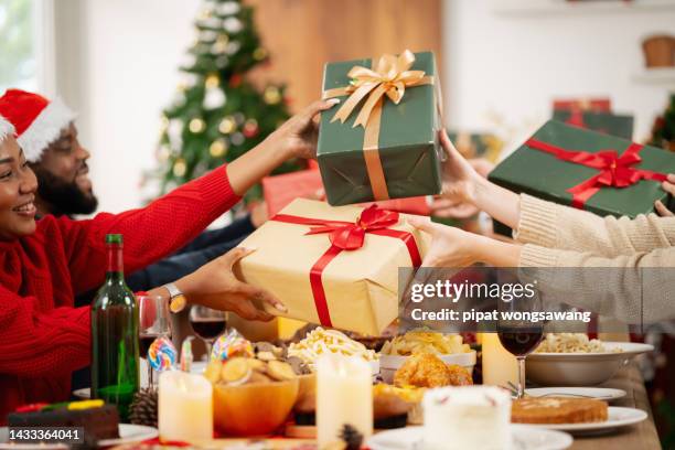 the family is happily exchanging gifts at christmas. - christmas presents stockfoto's en -beelden