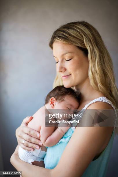 newborn baby in mother's arms - adult diaper stockfoto's en -beelden