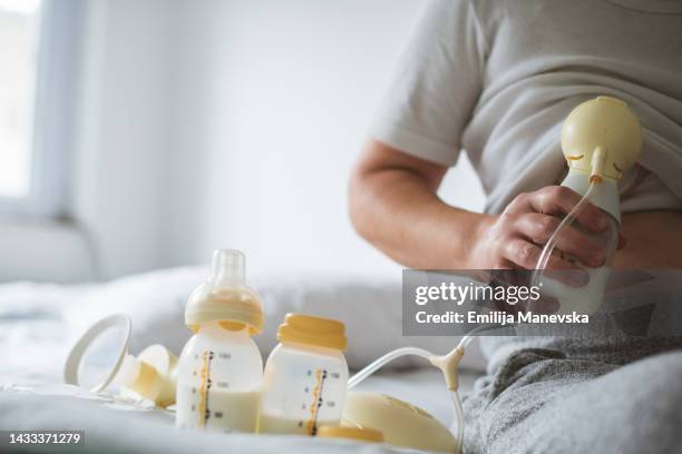 woman holding breast pump bottle - 胸 ストックフォトと画像