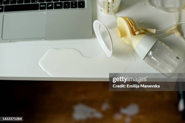 woman pumping breast milk while working form home - milk pumping ストックフォトと画像