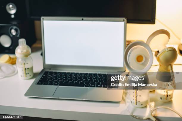 woman pumping breast milk while working form home - working mother stock pictures, royalty-free photos & images