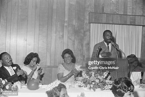 During an SCLC banquet at the Redmont Hotel, American comedian and Civil Rights activist Dick Gregory speaks from a lectern as, seated from left,...
