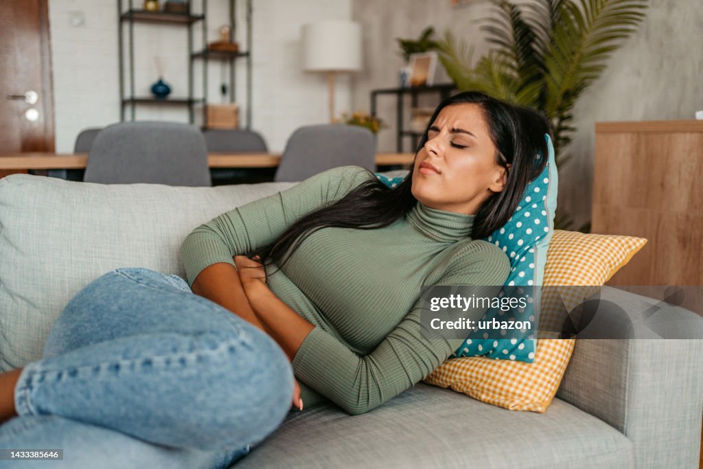 Young Woman Having Period Cramps At Home
