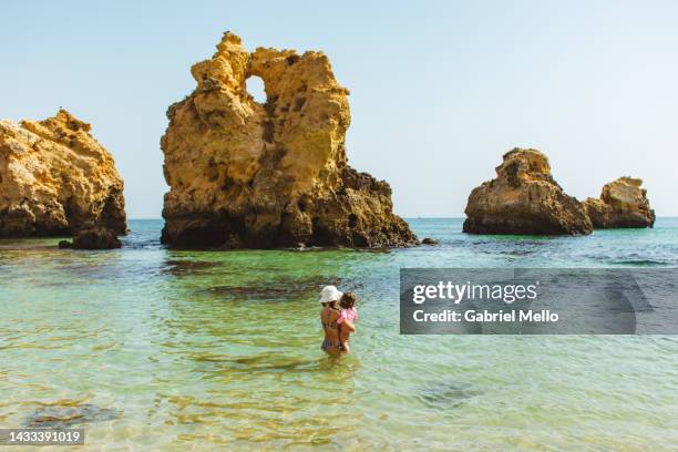 woman bonding with baby girl at the beach - albufeira beach stock pictures, royalty-free photos & images