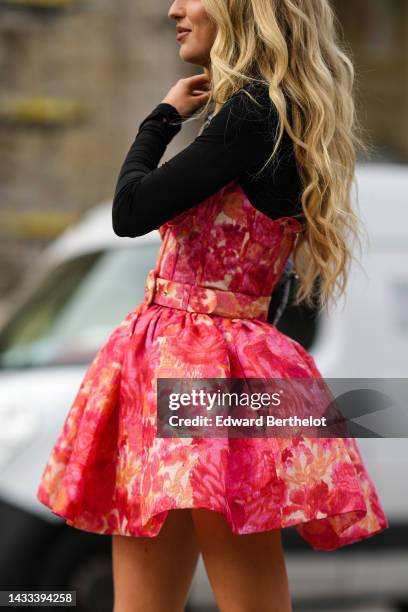 Emili Sindlev wears a black long sleeves t-shirt, a red / orange / pale yellow tie and dye print pattern shoulder-off / puffy short sleeves, a blue...