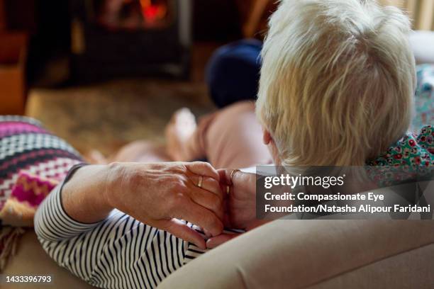 senior lesbian couple relaxing on sofa at log cabin - couple close up not smiling stock pictures, royalty-free photos & images