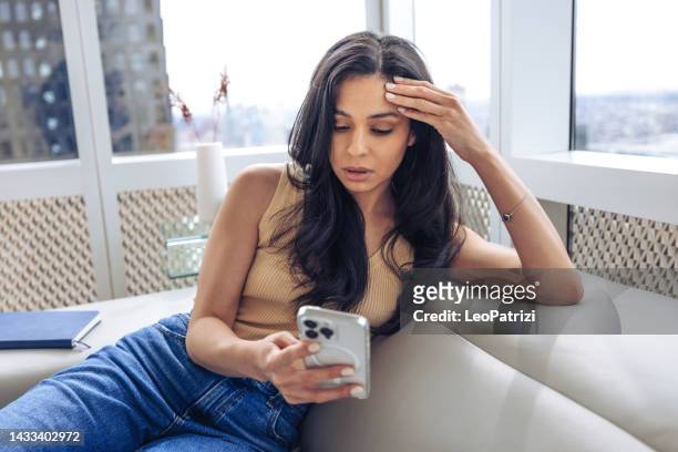 une femme lisant une mauvaise nouvelle au téléphone - shock stock photos et images de collection
