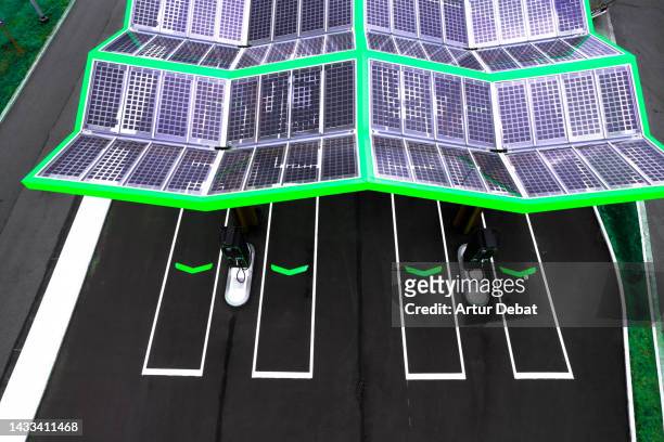 aerial view of electric charging station carport with vivid green color and covered with solar panels in the western europe. - belgium aerial stockfoto's en -beelden