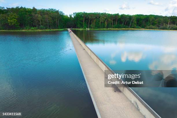 drone view of creative bike path crossing through the water like magic in belgium. - wow stock-fotos und bilder