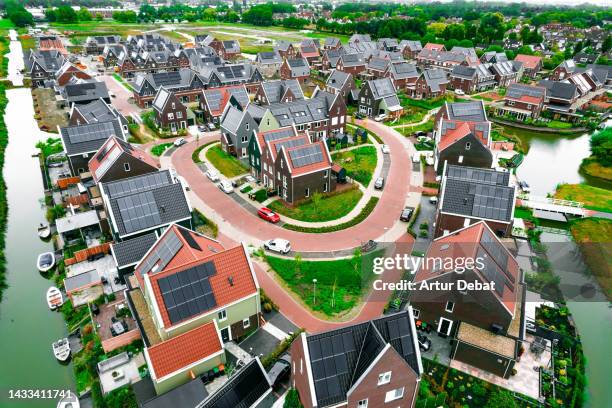 aerial view above sustainable neighborhood with full solar panels in the netherlands. - holland holland stockfoto's en -beelden