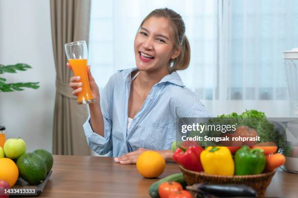 healthy woman drinking juice at home - woman lick knife stock pictures, royalty-free photos & images